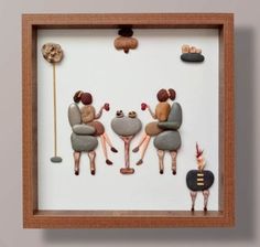 three people sitting on rocks in a shadow box