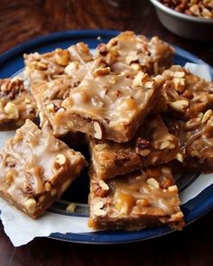 several pieces of food on a plate with some nuts in the middle and another bowl behind it