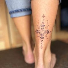 a woman's foot with a tattoo design on the side of her leg,