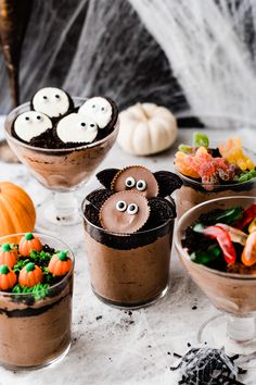 halloween desserts with chocolate pudding and candy eyes in small glass dishes on a table