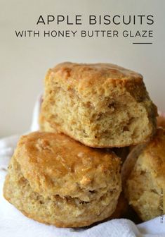 three apple biscuits with honey butter glaze stacked on top of each other in a white paper towel