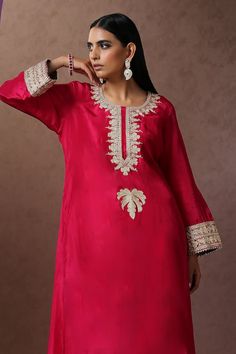 Hot pink A-line kurta crafted in silk base with placement kashmiri tilla embroidery. Paired with a salwar, highlighted with kashmiri tilla embroidered hem.
Components: 2
Pattern: Embroidery
Type Of Work: Kashmiri Tilla
Neckline: Round Neck
Sleeve Type: Full Sleeves
Fabric: Silk
Color: Pink
Other Details: 
Length:
Kurta: 47 inches
Salwar: 38 inches
Approx. product weight: 1 kg
Model height: 5ft 7inches, wearing size S
Inner lining
Occasion: Sangeet - Aza Fashions Salwar Women, Kashmiri Tilla Embroidery, Tilla Embroidery, Embroidered Hem, A Line Kurta, Pattern Embroidery, Silk Embroidery, Fabric Silk, Full Sleeves