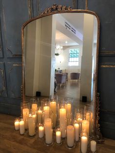 a large mirror sitting on top of a table filled with candles