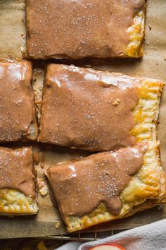 there are four pieces of food on the baking sheet and one is covered in brown icing