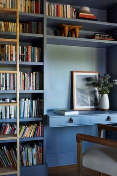 a bookshelf filled with lots of books next to a chair