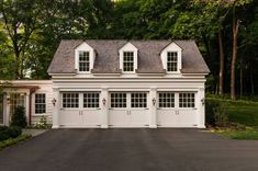 a white two story house with three windows on the top floor and one above the garage