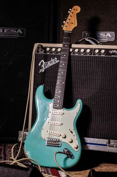 an electric guitar sitting on top of a table next to two amps and a speaker