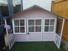 a small pink house with windows and doors