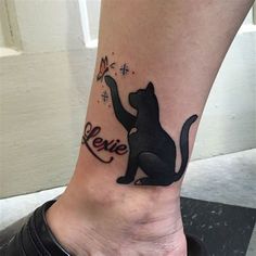 a black cat with the word love on it's side tattooing its paw