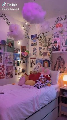 a bedroom with pink lighting and lots of pictures on the wall above the headboard