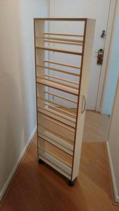 an empty room with a book shelf on the floor and a door open to another room