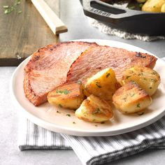 a white plate topped with meat and potatoes