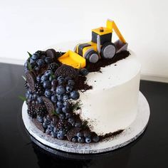 a white cake topped with blueberries and a tractor