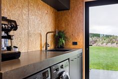 a kitchen with a washer and dryer next to a sliding glass door that leads outside