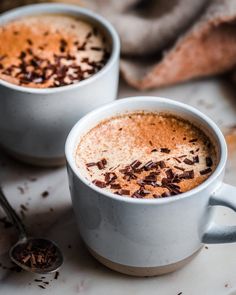 two mugs of hot chocolate with cinnamon sprinkles