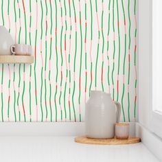 a white shelf with two vases sitting on top of it next to a wall