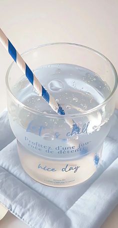 a glass bowl filled with water and a blue striped straw