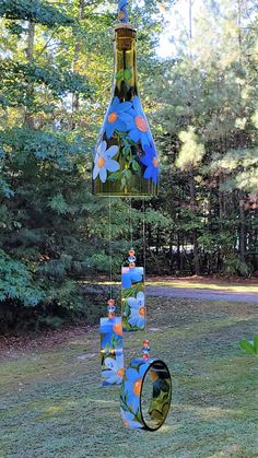 a wind chime hanging from the side of a tree in a yard with trees behind it