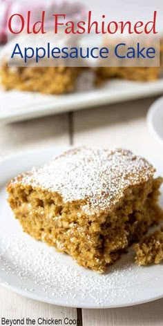 an old fashioned appleauce cake on a white plate with powdered sugar over it