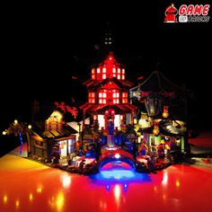 a building made out of legos on top of a red floor in the dark