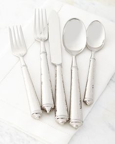 five silverware pieces on a white napkin