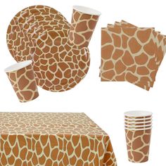 a giraffe print table cloth and napkins with cups on it, set of four