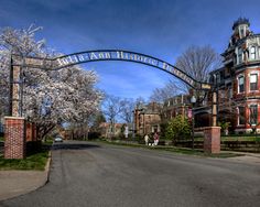 the entrance to an old brick building with a large metal arch over it's entrance