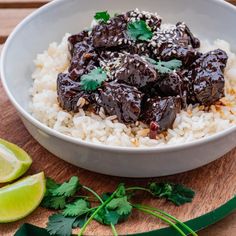 a white bowl filled with rice covered in sauce and garnished with cilantro