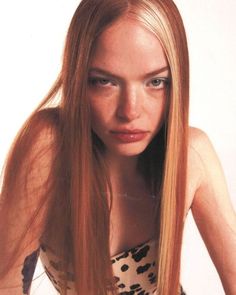 a woman with long red hair is posing for the camera