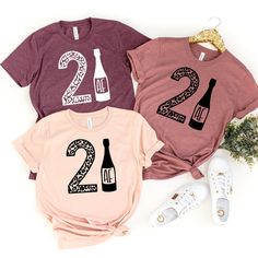 three t - shirts with the number two and wine bottles