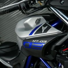 the front end of a motorcycle with blue and silver stripes on it's side