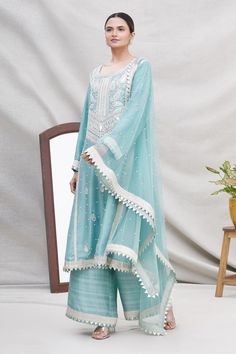 Powder blue kalidar kurta with silver -tone ambi motif dori hand work and cutwork hem. Comes with wide-legged pants and embellished dupatta.
Components:3
Embroidered
Neckline:Round
Sleeve Length:Full
Fabric:Silk
Color:Blue
Cuff sleeves
Back keyhole
Side panels
Elastic waistband
Cutwork border dupatta - Aza Fashions Silk Kurta Set, Kurta Set For Women, Silk Kurta, Embroidered Neckline, Fabric Silk, Hand Work, Kurta Set, Blue Silk, Cut Work