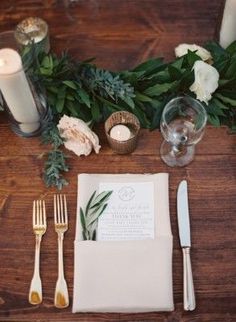 the table is set with silverware and flowers