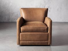 a brown leather chair sitting on top of a cement floor