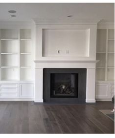 empty living room with white bookcases and fireplace