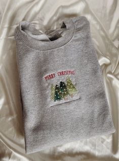 "Embroidered Merry Christmas Trees Sweatshirt -Embroidered on a cotton/polyester blend crewneck sweatshirt, this design is simple and minimalistic, perfect for every outfit! -Embroidery design measures 5\" x 1.5\". -See product pictures for shirt sizing chart. -All sweatshirts are handmade on an embroidery machine so there may be slight differences, but we only sell the sweatshirts that meet our high-quality standards. -To maintain the quality of your sweatshirt and the embroidery design make su Christmas Cotton Sweatshirt With Embroidered Logo, Christmas Long Sleeve Sweatshirt With Embroidered Text, Christmas Crew Neck Sweatshirt With Embroidered Logo, Casual Christmas Sweatshirt With Custom Embroidery, Holiday Embroidered Crew Neck Sweatshirt, Embroidered Crew Neck Sweatshirt For Holiday, Christmas Embroidered Crew Neck Sweatshirt, Christmas Crew Neck Sweatshirt With Embroidered Graphics, Embroidery Sweatshirt