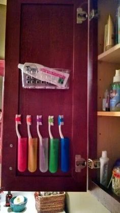 there are many different colored toothbrushes in the holder on the door way to the bathroom