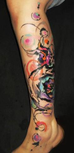 a person with a colorful tattoo on their arm and leg is standing in front of a black background