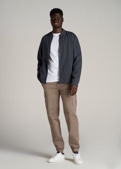 About Our Stretch Cotton Cargo Jogger Pants for Tall Men Looking for a casual pair of slacks for tall men with some stretch? Enter our Cotton Cargo Joggers. As comfortable as your favorite sweatpants but designed with a modern fit, these pants for tall men are easy wearing yet ultra-flattering. They have a mid-rise waist and tapered leg that lands at your ankle, and we made these just for tall guys from 6’3 to 7’1, so you can trust they’re at the right length for you. Each pair has also been pre Ankle Pants Outfit Men, Ankle Pants Outfit, Mens Joggers Outfit, Pants Outfit Men, Tall Men, Joggers Outfit, American Casual, Tall Pants, Casual Joggers