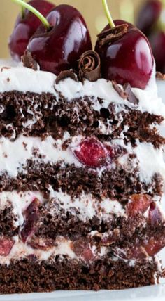 a piece of chocolate cake with cherries on top and white frosting in the middle