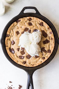 chocolate chip cookie with ice cream in a cast iron skillet on a white surface