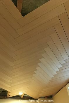 the ceiling is covered with wood planks and has light coming from it's top