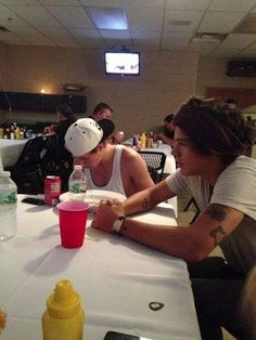 two people sitting at a table with drinks in front of them