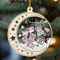 an ornament hanging from a christmas tree decorated with stickers and snowflakes