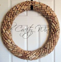 a wreath made out of wine corks hanging on a door with the words crafty wine written in cursive font