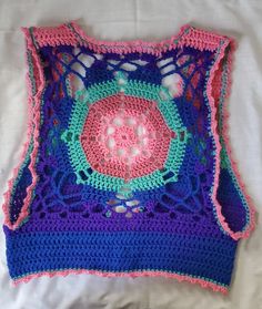 Beautiful multi-colored mandala pattern vest.  Wear alone or over a cami or shirt.  The vest is made from acrylic yarn in pink, rose, purple, blue and teal. It measures 42" at bottom of armpits and is 42" long.  Please see picture with size notations.  Please note that there is some adjustment larger with loosening the ties.   Feel free to ask any questions and thanks for looking. Fitted Multicolor Tank Vest, Blue Bohemian Handmade Crochet Top, Handmade Bohemian Blue Crochet Top, Handmade Blue Bohemian Crochet Top, Handmade Bohemian Blue Tops, Handmade Blue Bohemian Tops, Handmade Blue Tops For Festival, Hippie Sleeveless Cotton Crochet Top, Sleeveless Cotton Crochet Hippie Top