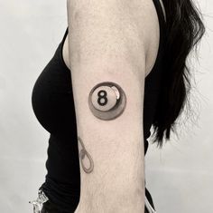 a woman's arm with a tattoo on it that has a eight ball in the middle