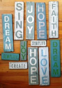 some wooden signs that are hanging on a wood wall with the words dream, hope, inspire and simply create