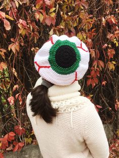 a woman wearing a knitted hat with an eyeball on it