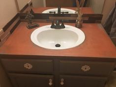 a bathroom sink sitting on top of a wooden counter